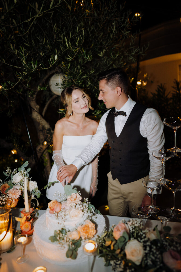 Couple cutting cake at night, intimate reception moment