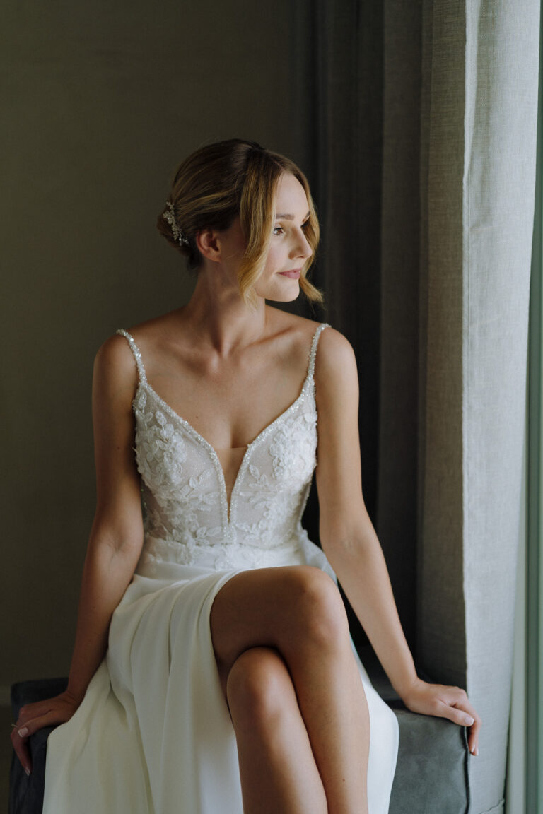 Bride sitting by the window, intimate getting ready moment