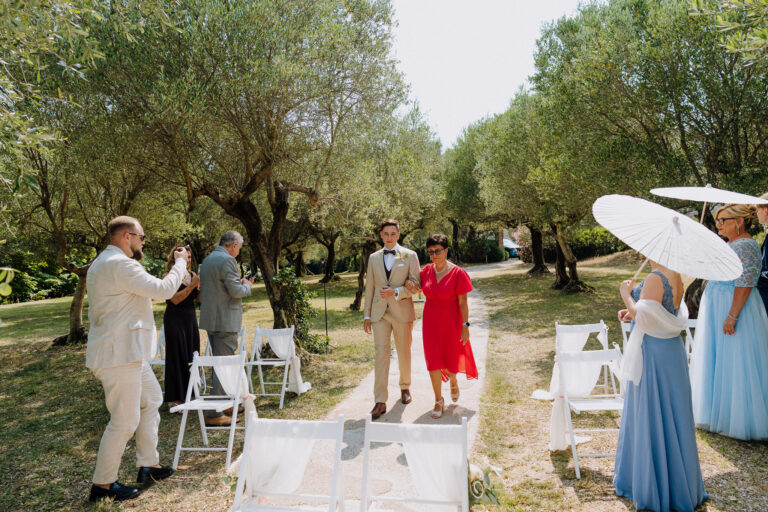 Groom walking with mother at ceremony in Sirmione on Lake Garda