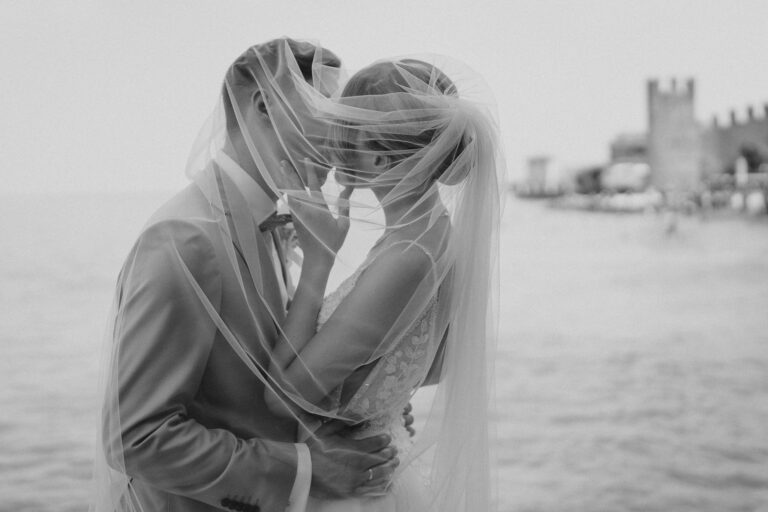 Black and white couple veil portrait, intimate moment by Lake Garda