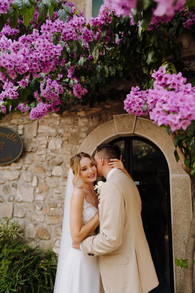 Bride and groom close portrait under flowers, romantic moment