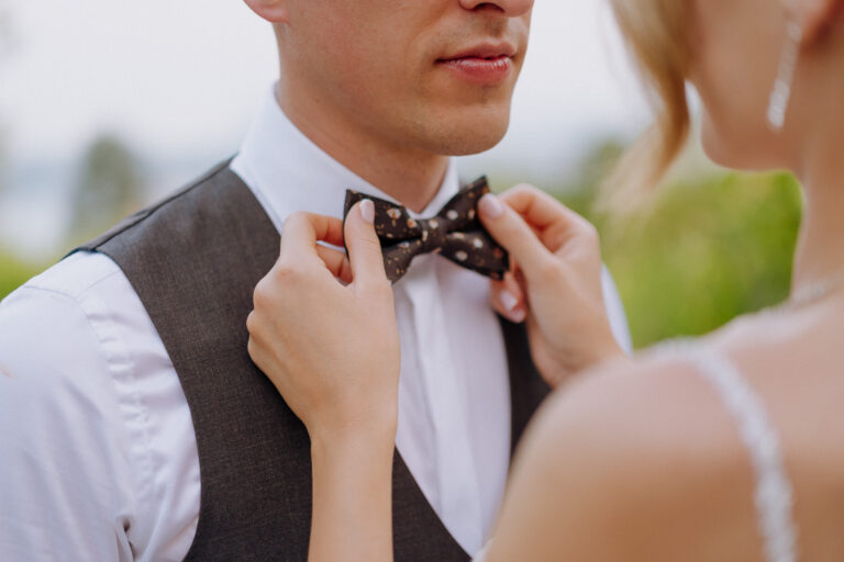 Bride adjusting bow, candid detail during reception