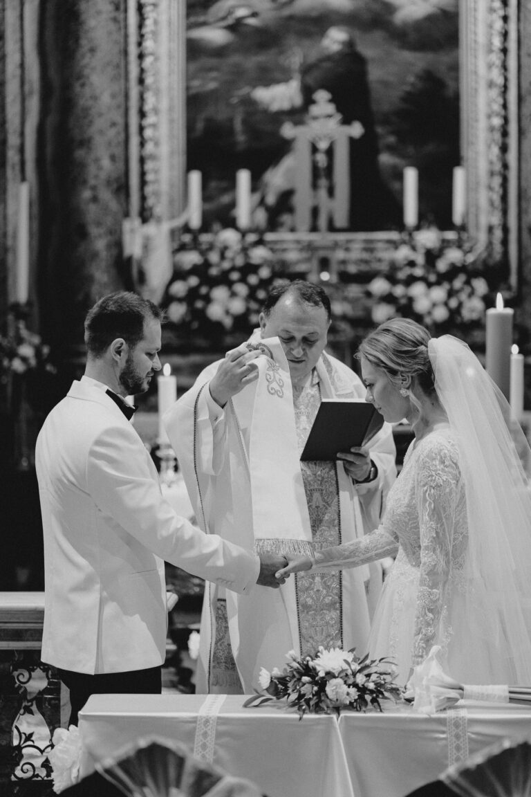Black and white ceremony moment inside San Stanislao dei Polacchi in Rome.