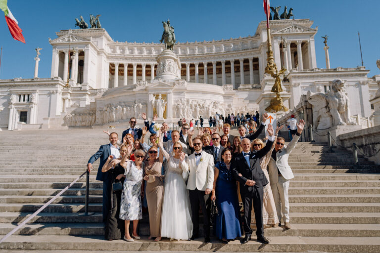 Wedding group photo in Rome at Altare della Patria, guests celebrating after the ceremony.