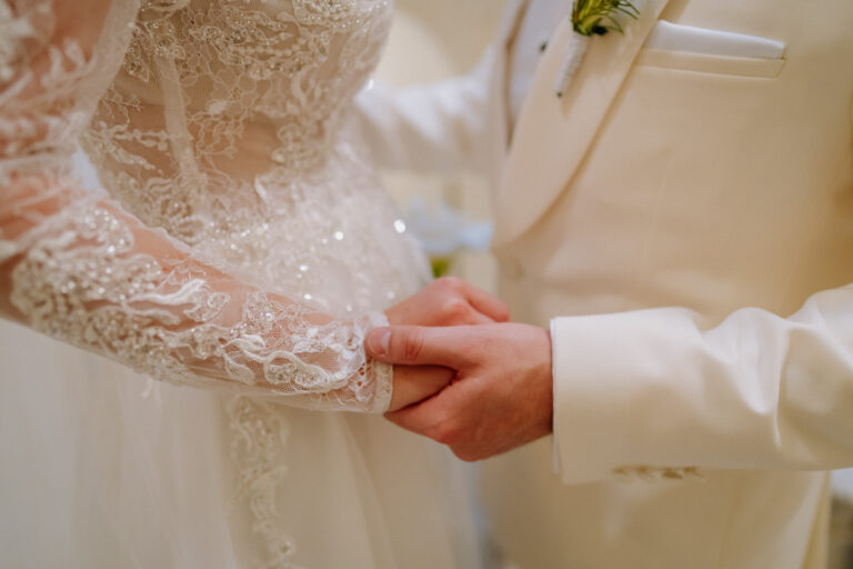 Bride’s hand and rings detail, soft light wedding close-up.