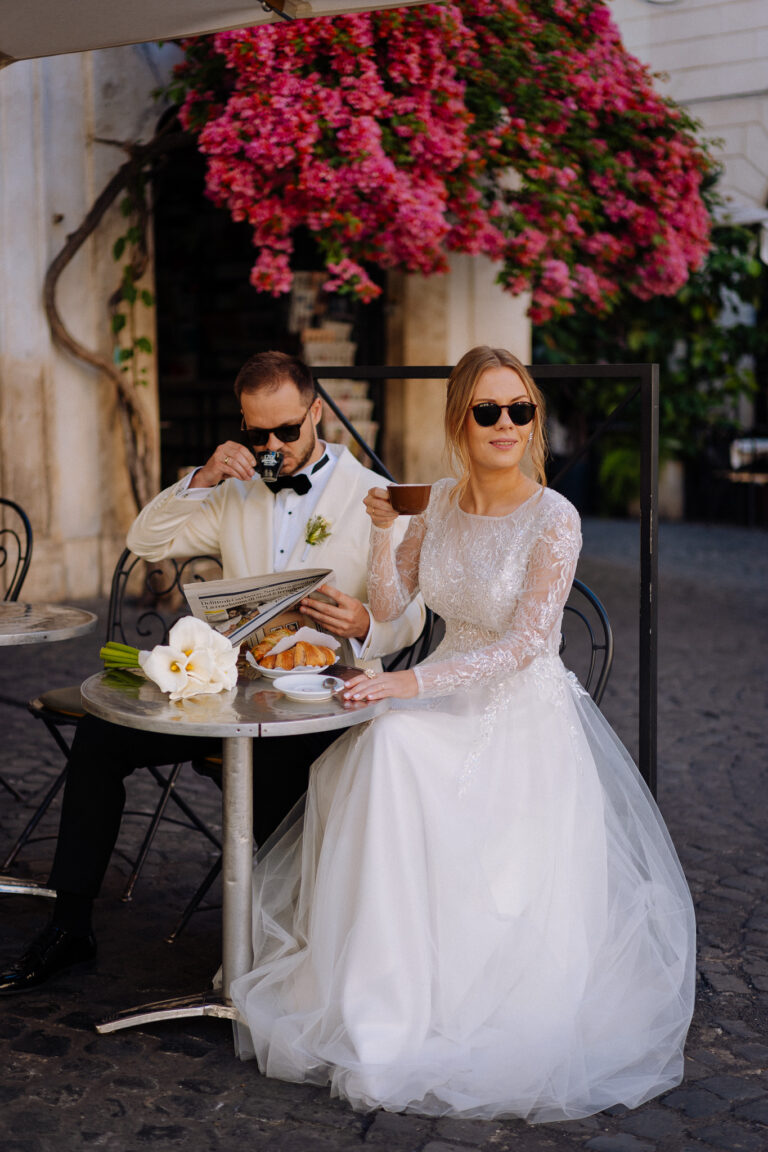 Bride portrait by a café table in Rome with pink flowers overhead