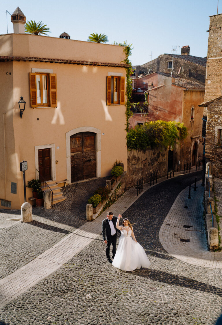 Couple walking in a Tivoli street, Italy, relaxed destination wedding feel.