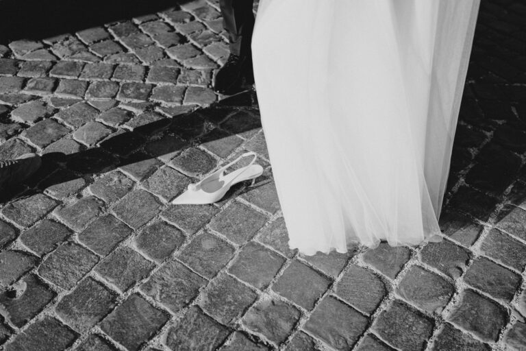Close-up detail of the wedding dress hem on Roman cobblestones