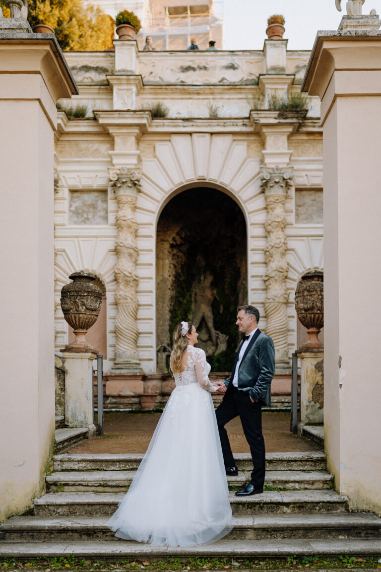 Couple portrait in front of historic Villa d’Este architecture in Tivoli.