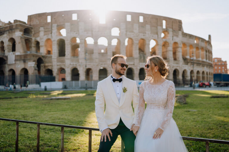 Bride and groom in front of the Colosseum, warm evening light.