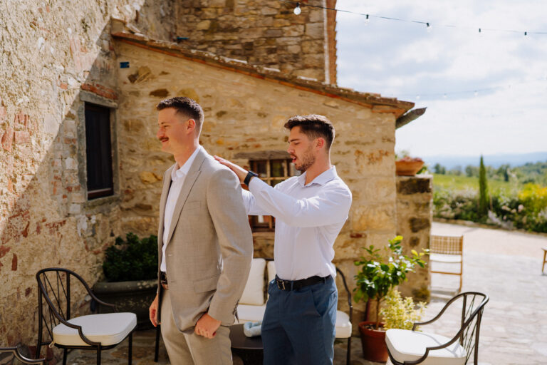Groomsmen helping with jacket, getting ready in Tuscany