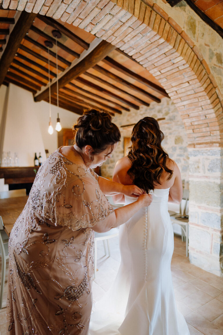Bride dress being adjusted, candid getting ready moment