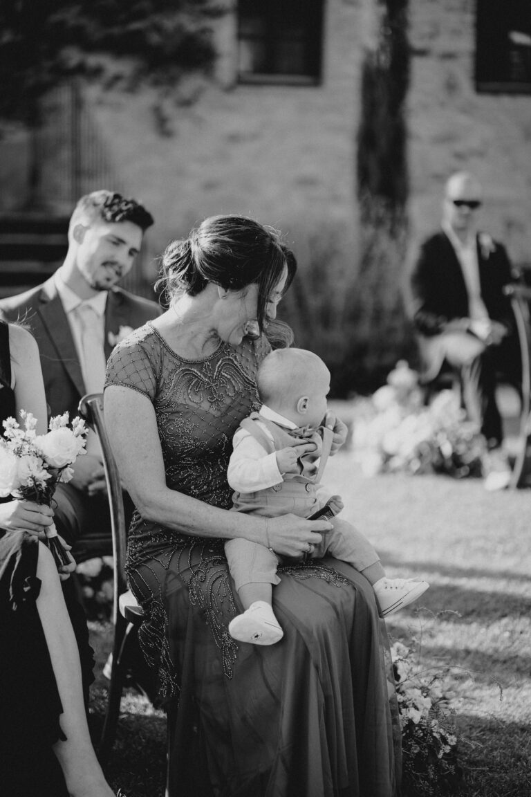 Guest holding a child during the ceremony, candid moment
