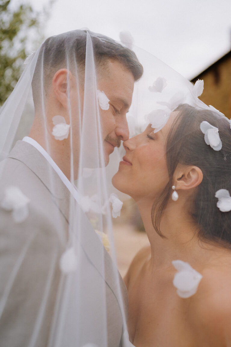 Close-up kiss under the veil, romantic wedding moment