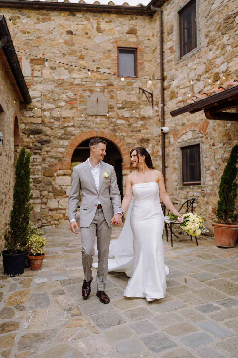 Bride and groom walking away together, Chianti countryside.