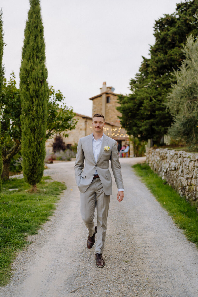 Groom walking along a Tuscan path, wedding portrait
