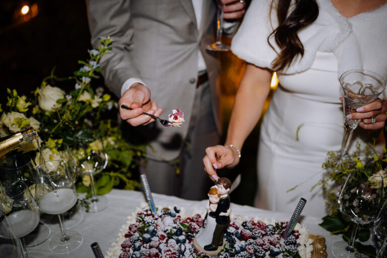 Hands cutting the wedding cake, close-up detail