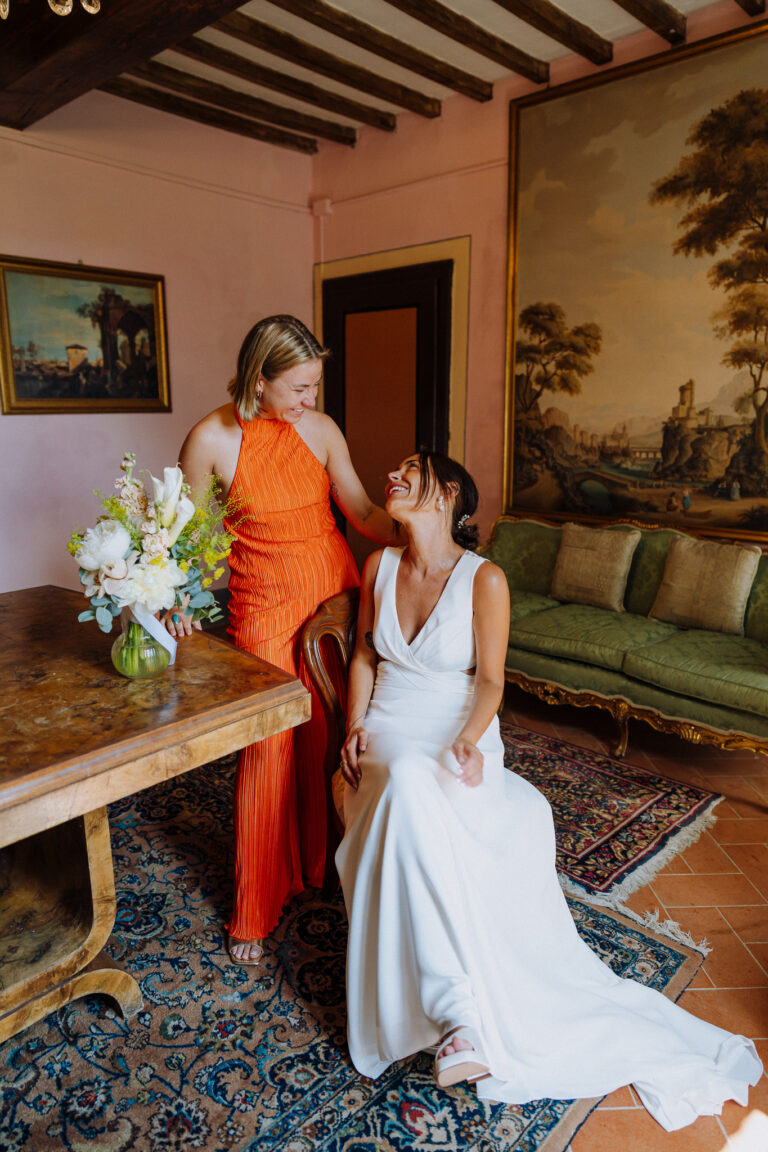 Bride sitting with bouquet, getting ready in Tuscany