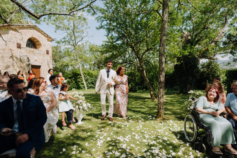 Groom walking the aisle with his mum